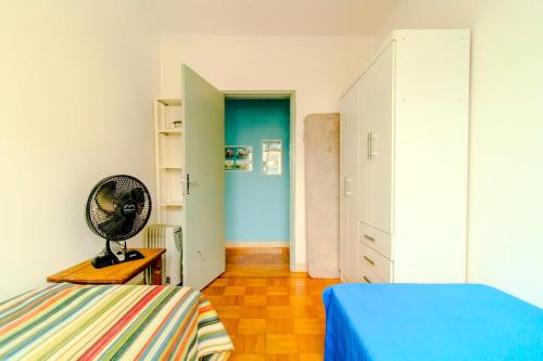 a bedroom with a bed and a fan on a table at Apto com Wi Fi proximo ao centro Porto Alegre RS in Porto Alegre