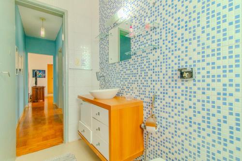 a bathroom with a sink and blue and white tiles at Apto com Wi Fi proximo ao centro Porto Alegre RS in Porto Alegre