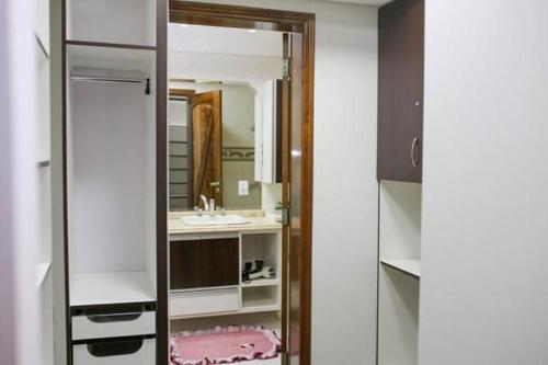 a bathroom with a mirror and a sink at Aconchego familiar in Foz do Iguaçu