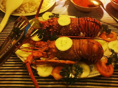 ein Teller mit Meeresfrüchten und Gemüse auf dem Tisch in der Unterkunft Villa Sea View in Galle