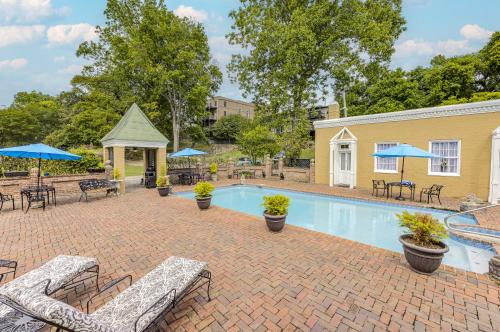 a pool with chairs and tables and umbrellas at The Inn at Cedar Grove in Vicksburg