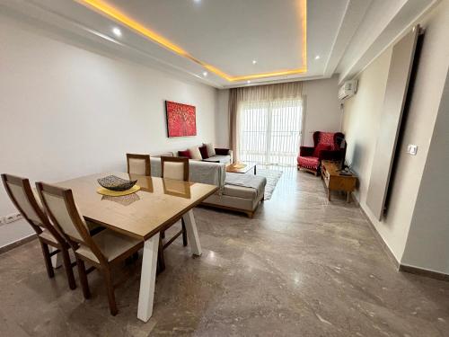 a living room with a table and a couch at Abilia Suite - À Proximité de l'Aéroport - Confort et Élégance in La Soukra