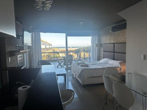 Un dormitorio con una cama y una mesa y sillas. en Linda Bay Spa Apartments, en Mar de las Pampas