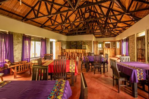 a dining room with purple tables and chairs at MISE CAVE LODGE in Kapchorwa
