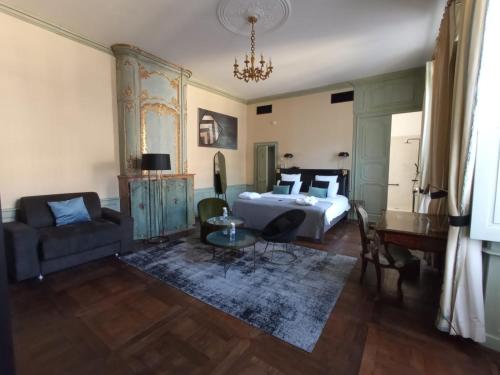 a bedroom with a bed and a couch and a table at Mercure Figeac Viguier du Roy in Figeac