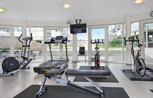 a gym with several treadmills and elliptical machines at Haugesund centrum apartment in Haugesund