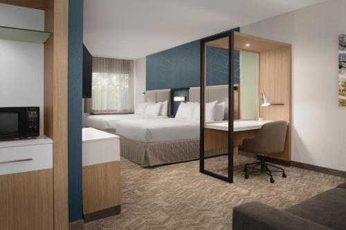 a hotel room with two beds and a desk at SpringHill Suites By Marriott Charleston Airport & Convention Center in Charleston