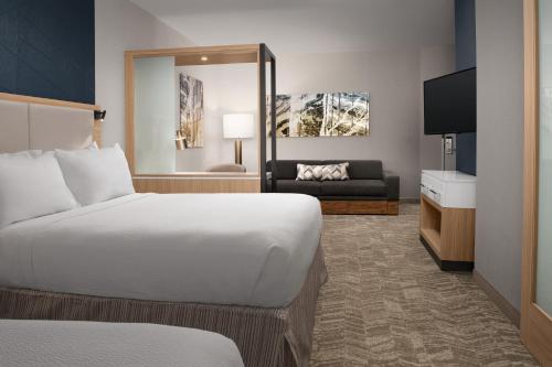 a hotel room with a bed and a couch at SpringHill Suites By Marriott Charleston Airport & Convention Center in Charleston