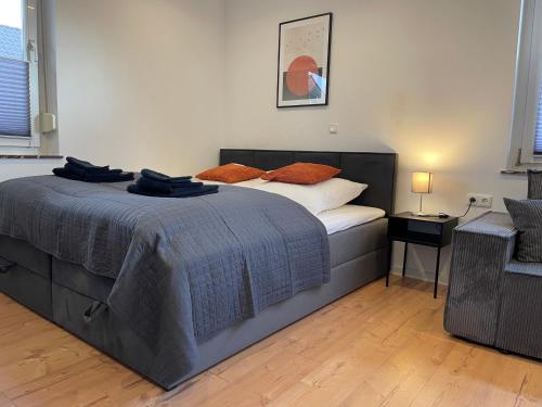 a bedroom with a bed and a chair in it at LIGHTPLACE • Große Unterkunft • 3 Schlafzimmer • Boxspring • Smart TV • Biergarten • Restaurant in Braunschweig