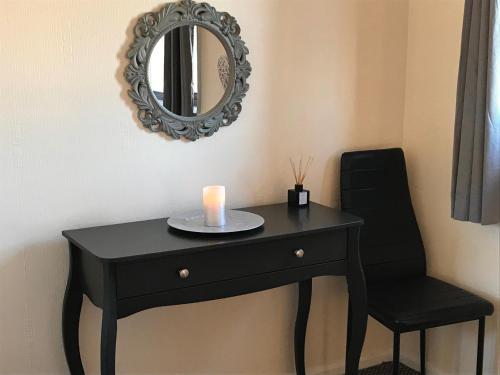 a black table with a candle and a mirror at Lavender Cottage in Thirsk