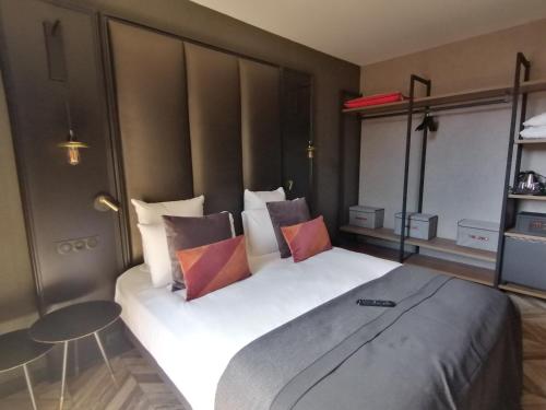 a bedroom with a large bed with four pillows at Mercure Figeac Viguier du Roy in Figeac