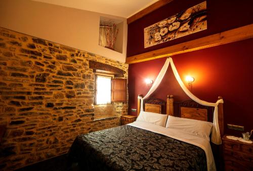 a bedroom with a stone wall and a bed at ZELAI in Mallavia
