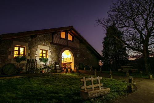 a stone house with a gate in front of it at night at ZELAI in Mallavia
