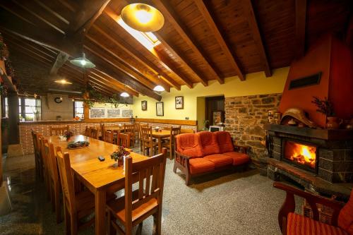 a restaurant with a fireplace and wooden tables and chairs at ZELAI in Mallavia