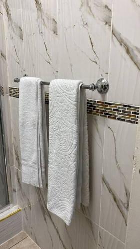 Un baño con toallas blancas colgando de un toallero. en 1 Cozy Bedroom Apartment, en Kingston
