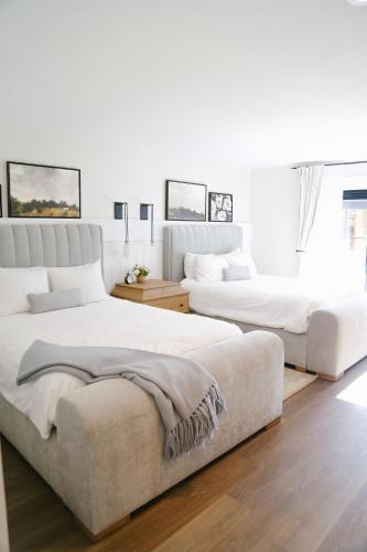 two beds in a bedroom with white walls and wood floors at Homestead Resort in Midway