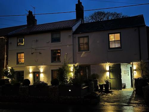 a white house with its lights on at Stable Yard Rooms in Richmond