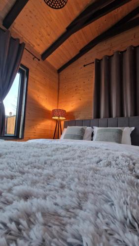 a bedroom with a large bed and a window at Kenzo Chalet in Porumbacu de Sus