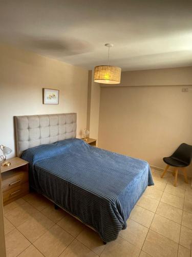 a bedroom with a blue bed and a chair at Bv San Juan - Nva Cba in Córdoba