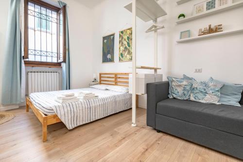 um quarto com uma cama e um sofá em Cozy Apartment in Monza City Center em Monza