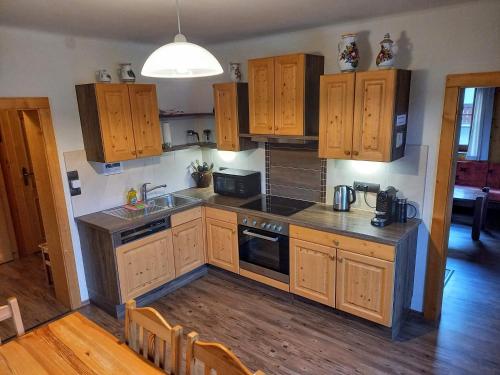 a kitchen with wooden cabinets and a stove top oven at Appartement Jana in Flattach