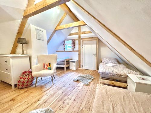 a attic room with a bed and a chair at Santova roubenka in Štramberk