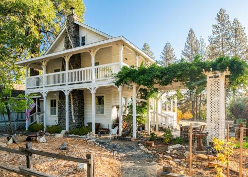 an old house with a garden in front of it at Inn at Sugar Pine Ranch in Groveland