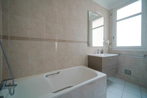 W łazience znajduje się wanna i umywalka. w obiekcie Appartement Arc de Triomphe - Neuilly - II w mieście Neuilly-sur-Seine