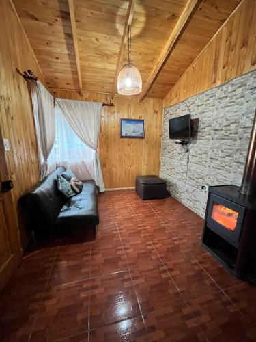 ein Wohnzimmer mit einem Sofa und einem Herd in der Unterkunft Cabañas Rukaparra in Pinto