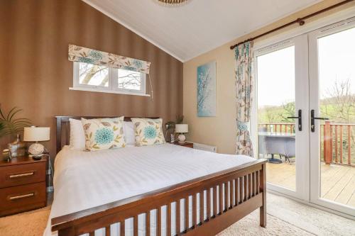 a bedroom with a bed and a balcony at Hideaway Lodge in Tintagel