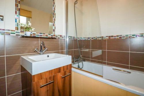 a bathroom with a sink and a bath tub at Hideaway Lodge in Tintagel