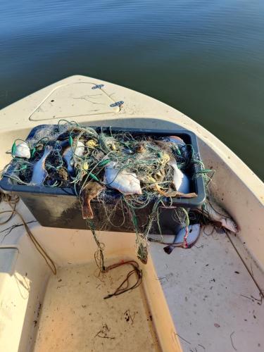 a boat with a container full of nets on the water at Villa-Amby in Ringkøbing