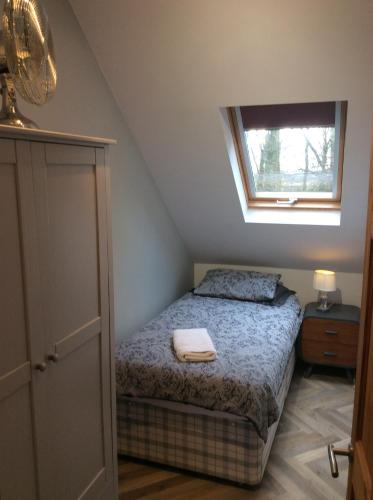 a small bedroom with a bed with a window at 2 Bedroom Furnished Apartment in a Rural Position in Stone