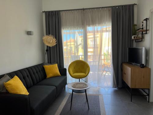 a living room with a couch and a yellow chair at Aloha Apartman Arguineguin in Arguineguín