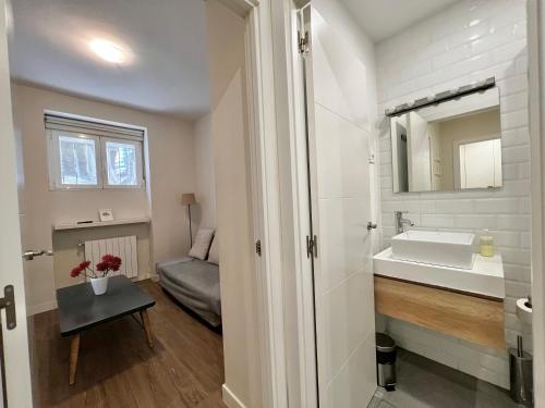 La salle de bains est pourvue d'un lavabo et d'un miroir. dans l'établissement Apartamentos Chamberí, à Madrid