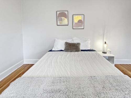 a white bedroom with a large bed with white sheets at Cozy 3br Home By Ingersoll Restaurant Scene in Des Moines