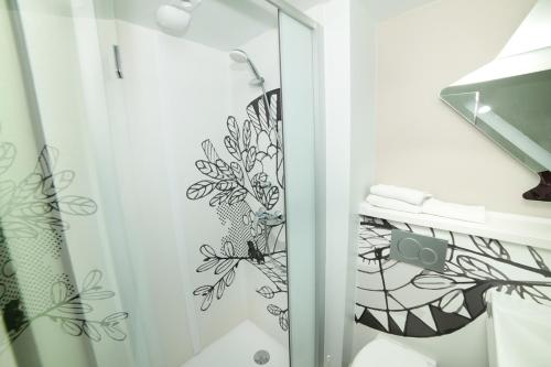 baño con ducha y puerta de cristal en Accueil Hotel Besançon, en Besançon