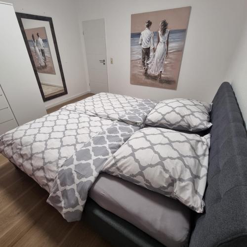 ein Bett mit einer Bettdecke und Kissen im Schlafzimmer in der Unterkunft Emma in Oldenburg