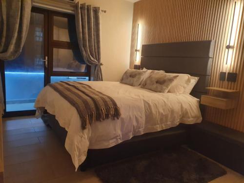 a bedroom with a large bed with a window at Sunset Retreat at Bay Point in Cape Town