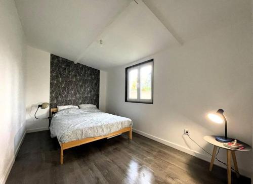 een slaapkamer met een bed, een raam en een tafel bij Charmante maison avec extérieur in La Queue-en-Brie