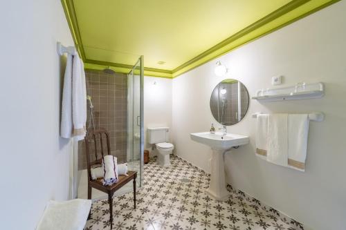 ein Badezimmer mit Waschbecken, Toilette und Spiegel in der Unterkunft Casa d' Alem in Mesão Frio