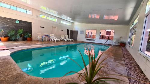 una piscina en una habitación grande con mesas y sillas en Complejo Cabañas Piriápolis, en Piriápolis