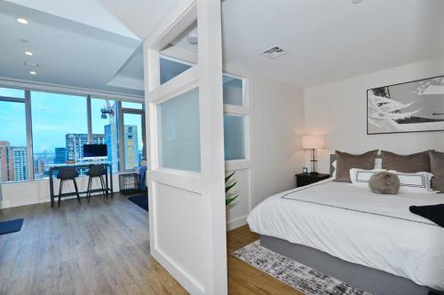 a white bedroom with a bed and a desk in it at Modern Seaport Oasis in Boston