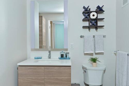 a bathroom with a sink and a toilet and a mirror at Modern Seaport Oasis in Boston