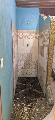 a bathroom with a shower with a rock floor at Finca Mamacita in Rusia