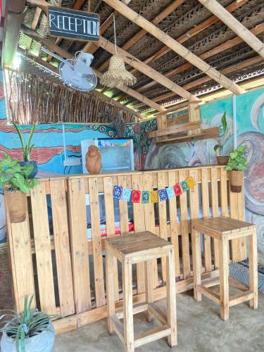 a restaurant with two wooden tables and a mural at Happy Hammocks, Hiriketiya Beach - Sri Lanka in Hiriketiya