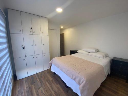 1 dormitorio con 1 cama y armarios blancos en Cabaña de Campo Las Hortensias en Chimbarongo