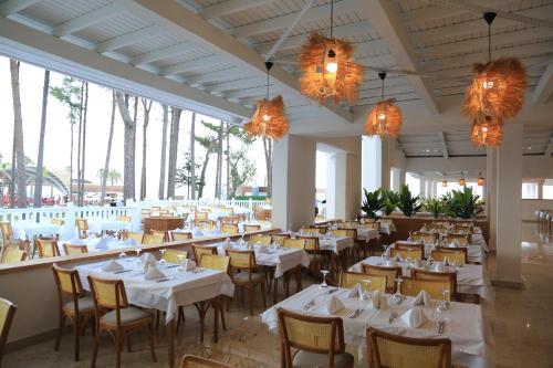 a restaurant with white tables and chairs and chandeliers at Siu Collection in Beldibi