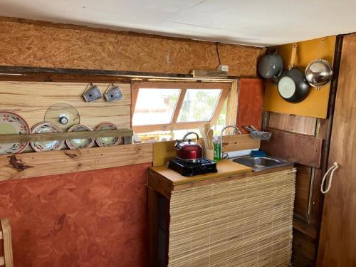 uma pequena cozinha com um balcão e um lavatório em Solar Valizas em Barra de Valizas