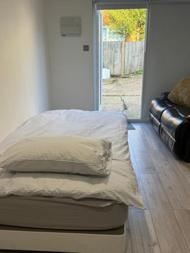 a unmade bed in a room with a couch at Modern 1BD apartment in London
